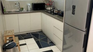 A compact kitchen with a refrigerator, microwave, and sink. - Comfy Private Home @ Sky.Pod (Puchong)