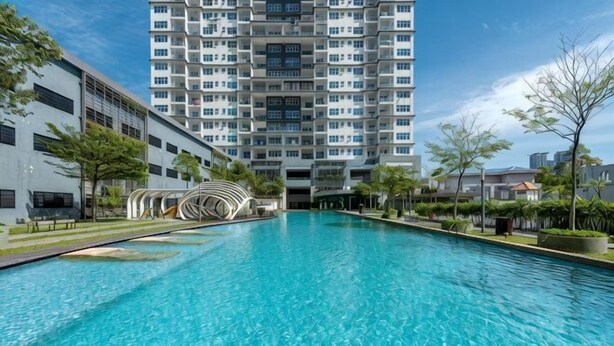 A swimming pool with a modern building in the background. - Comfy Private Home @ Sky.Pod (Puchong)