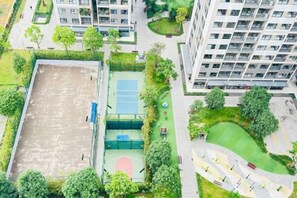 An aerial view of a residential area with a basketball court, tennis court, and a landscaped park. - Vesta Hill - Apartment Vinhomes Ocean Park Ha Noi (Hanoi)