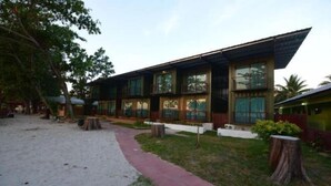 Un edificio moderno con amplias ventanas, un sendero y un pequeño jardín.