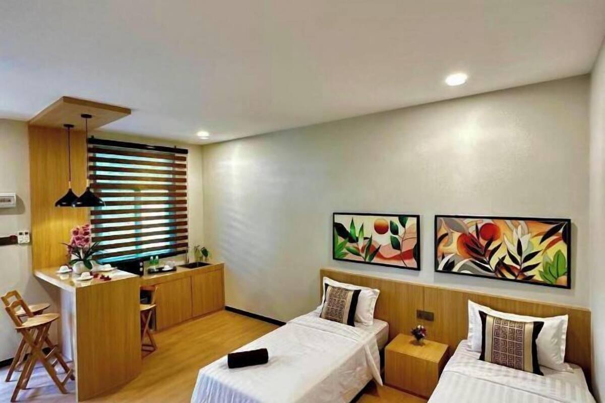 A hotel room with two beds, a desk, and a chair.