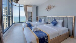 Een moderne hotelkamer met twee bedden, een groot raam en uitzicht op de stad.