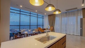 Een moderne keuken met een groot kookeiland, hanglampen en een uitzicht op de skyline.