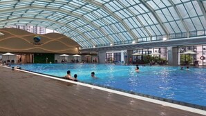 Una piscina interior con techo de cristal y varias pistas de natación.