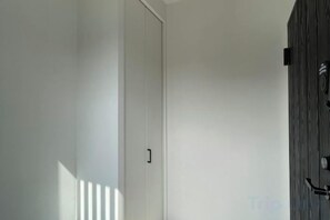 Un corridoio con una porta bianca e un muro in legno.
