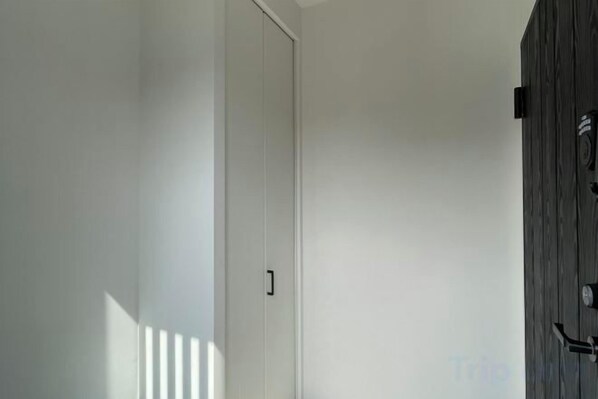A hallway with a white door and a wooden wall. - Biei Villa Gen (Kamikawa District)