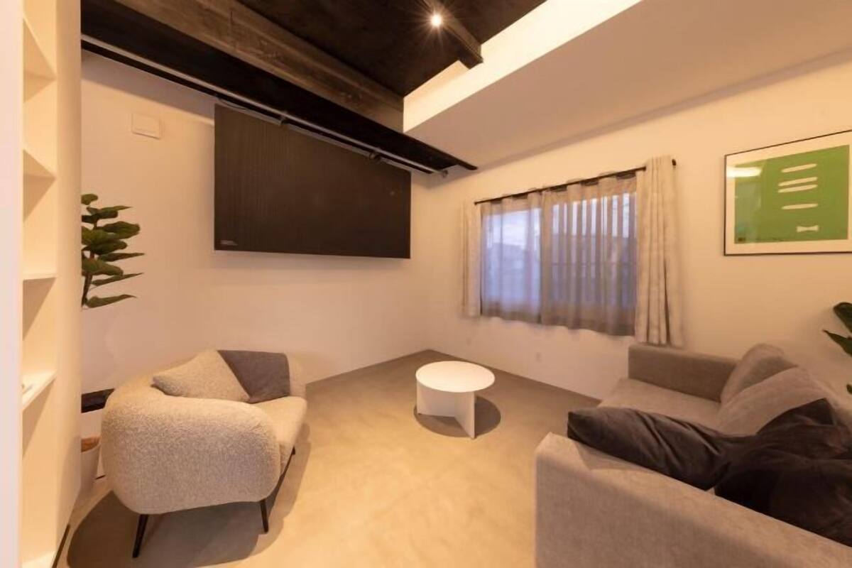 A modern living room with a sofa, armchair, and a round coffee table.