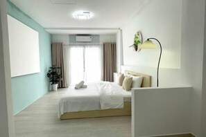 A modern hotel room with a bed, a bedside lamp, a potted plant, and a large window with curtains. - Ann Home (Ho Chi Minh City)