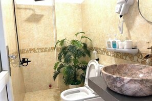 A bathroom with a shower, a toilet, a large marble sink, a potted plant, and a hairdryer on the wall. - Ann Home (Ho Chi Minh City)