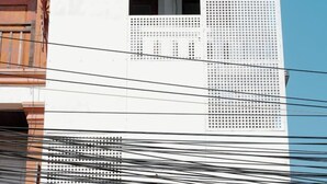Fachada de edificio con varios balcones y una serie de paneles perforados.