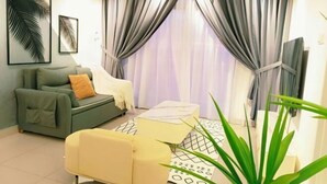 A living room with a sofa, a yellow armchair, a coffee table, and a large plant. - Apartment kulai (Kulai)