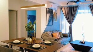 A modern dining area with a table set for four, a sofa, and a coffee table. - Apartment kulai (Kulai)