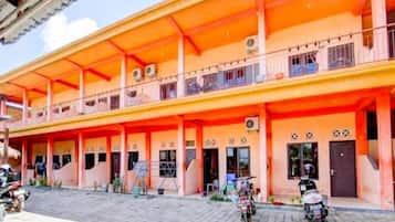 A two-story building with a covered balcony area and multiple doors.