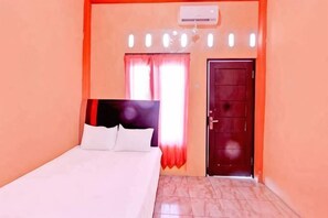 A bedroom with a bed, a door, and a window with curtains. - Penginapan Muslim Waker Syariah (Central Lombok Regency)