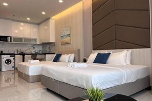 Une chambre d’hôtel moderne équipée de deux lits, d’un lave-linge et d’un coin cuisine.