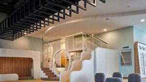 Een modern interieur met een trap, zitgedeeltes en een receptiebalie.