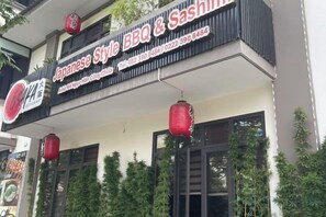 Een restaurant met een bord waarop staat dat er Japanse barbecue en sashimi geserveerd worden.