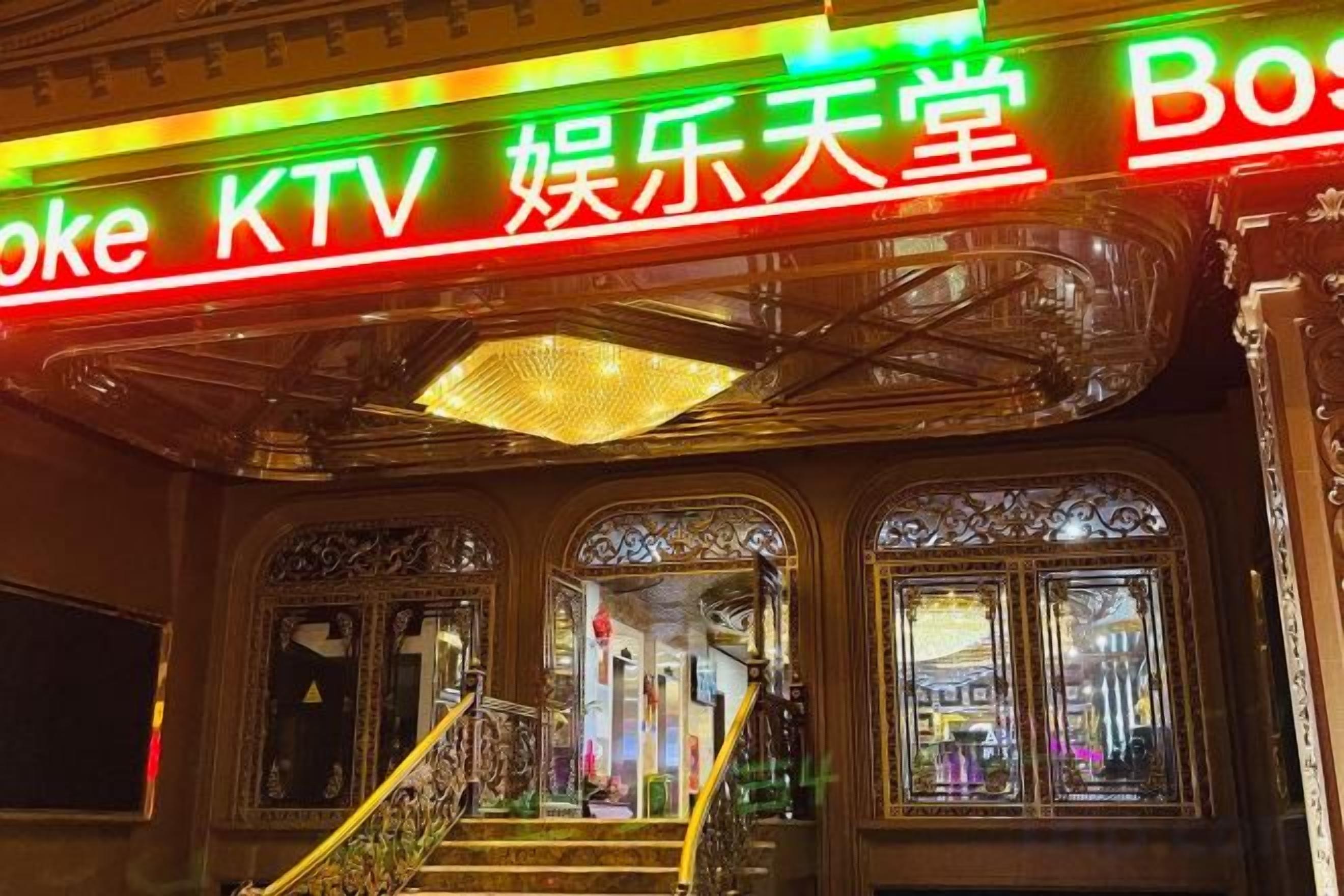 A building facade with a neon sign reading 'KTV' and 'Entertainment Hall.'