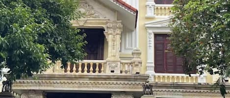 A building with ornate architectural details, including a balcony with intricate metalwork and a decorative entrance.