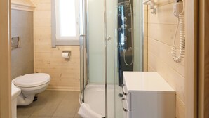 A modern bathroom with a glass-enclosed shower, a toilet, and a sink. - Collins Resorts are dream vacations for families with children right on the beach. (Sianożęty)