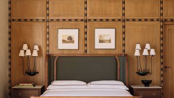 Quarto bem arrumado com uma cama grande, duas mesas de cabeceira com luminárias, quadros nas paredes e design de painel de madeira.