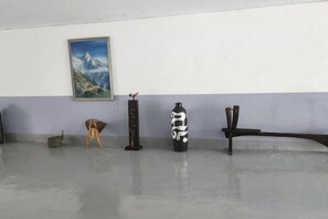 A room with a painting on the wall, a black and white vase, a wooden stool, and a black bench. - BUSAN YONGDO HAYANSUNG HOTEL (Busan)