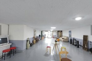 A spacious room with a long corridor, a sofa, and a television.