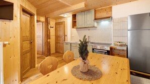 A wooden interior with a dining table, chairs, a refrigerator, and cabinets. - Apartment 'Jelerhof Hochstein' with Mountain View, Shared Garden and Wi-Fi (Gsies)
