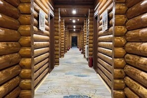 A log cabin interior with a central hallway, wooden walls, and a patterned floor. - Yingbin Garden Hotel (Almaty)