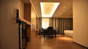 Une chambre d’hôtel comprenant un coin repas, un lit et une kitchenette.