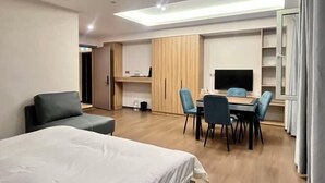 Une chambre d’hôtel comprenant un lit, un bureau, une chaise, une télévision et une armoire.
