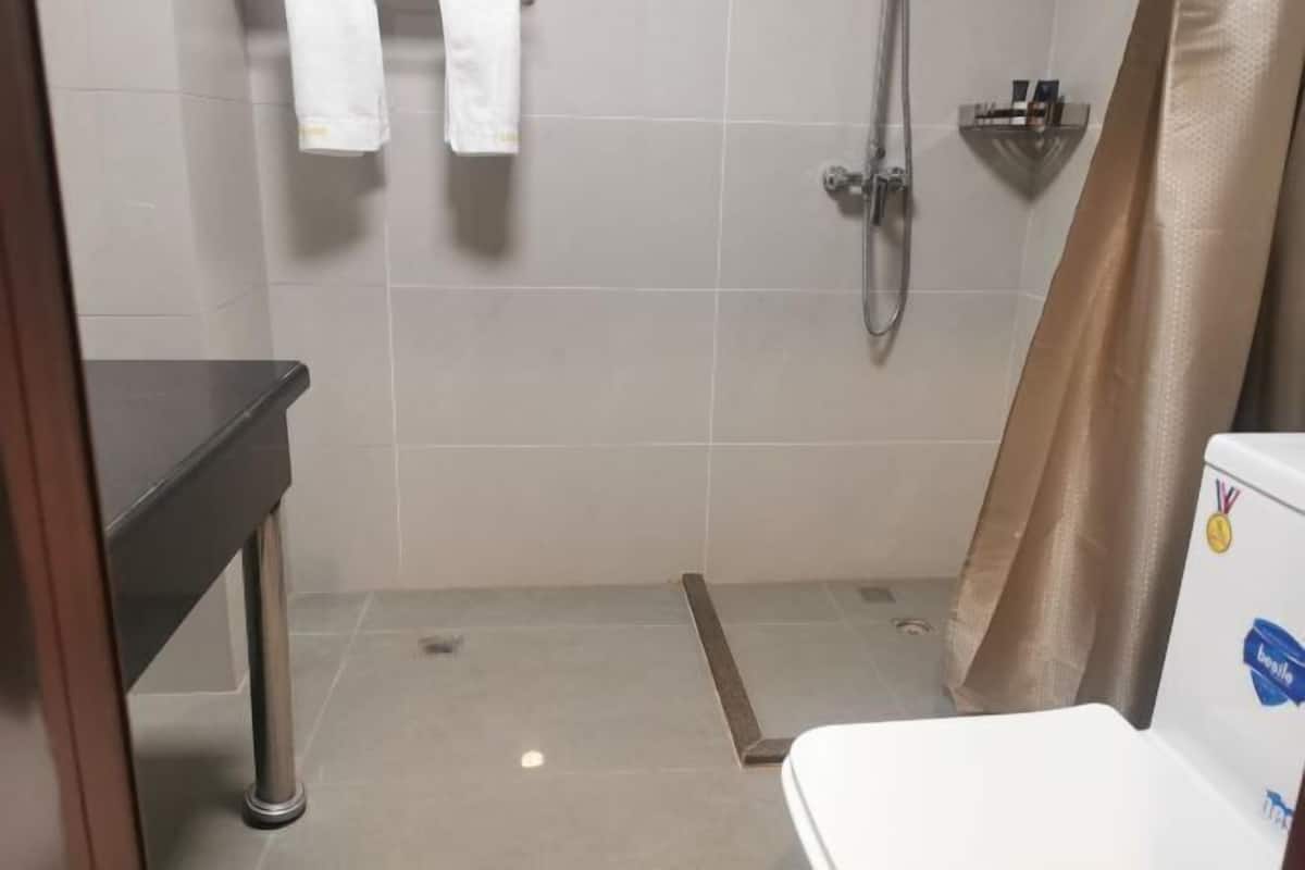 A bathroom with a shower, a toilet, and a sink.