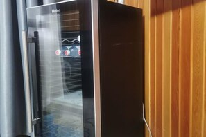 Un dispensador d'aigua amb una porta de vidre, un mànec metàl·lic i un panell de control amb botons.