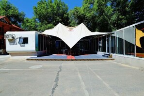 A tented outdoor area with a stage, seating, and a kiosk. - Yingbin Garden Hotel (Almaty)