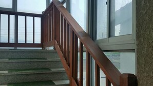 Una escalera de madera con barandillas de vidrio que sube a un piso superior.