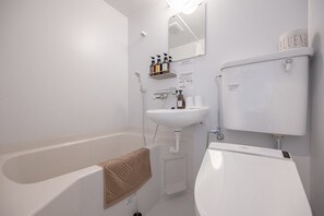 Kombinasi shower/bathtub, pengering rambut, kloset, dan handuk