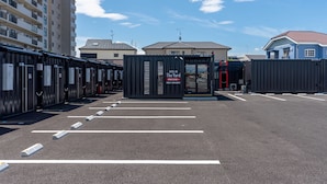 A hotel entrance with a modern design, featuring a reception desk and a parking area. - HOTEL R9 The Yard Honjowakaizumi (Honjo)