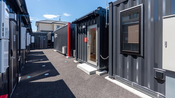 A row of compact, modern buildings with a uniform exterior design, featuring a narrow pathway between them. - HOTEL R9 The Yard Honjowakaizumi (Honjo)