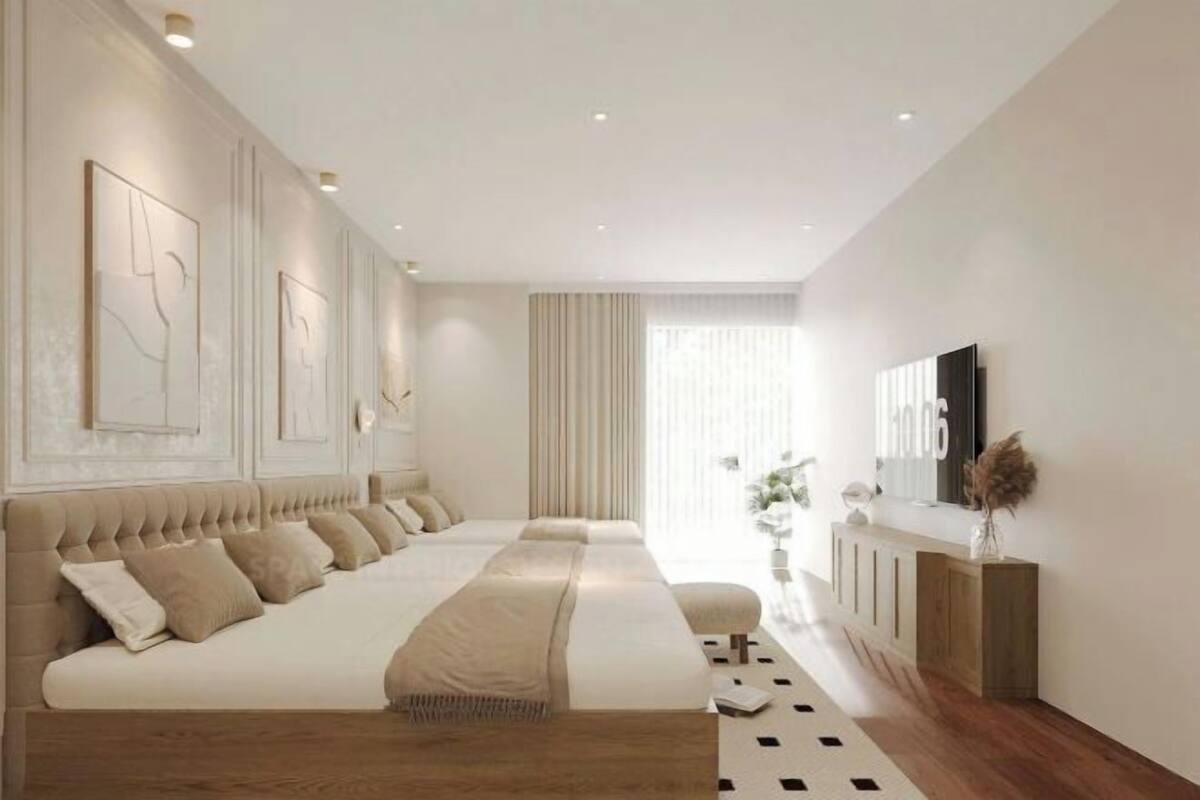 Une chambre à coucher moderne avec un grand lit, une télévision et une console.