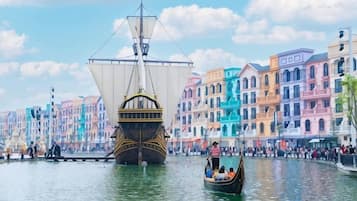 Un navire historique est amarré dans un canal, avec des bâtiments aux couleurs vives en arrière-plan.