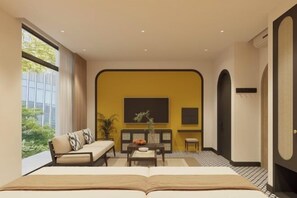 A modern hotel room with a large bed, a sofa, a dining table, and a view of greenery outside. - Grand Central Hotel- Vinhomes Ocean Park 3 (Nghia Tru)