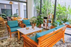 Un hall d’hôtel avec des meubles en bois, une table basse et une bibliothèque.
