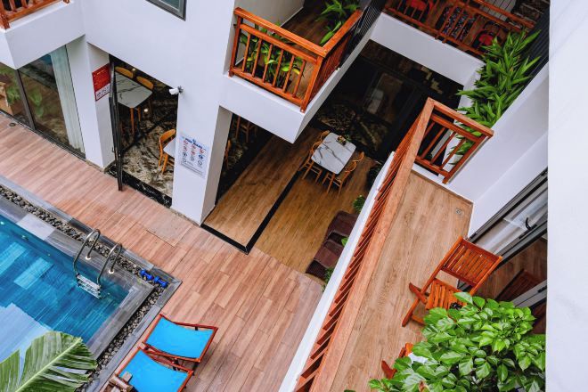 A multi-level indoor space with a pool, wooden flooring, and furniture.