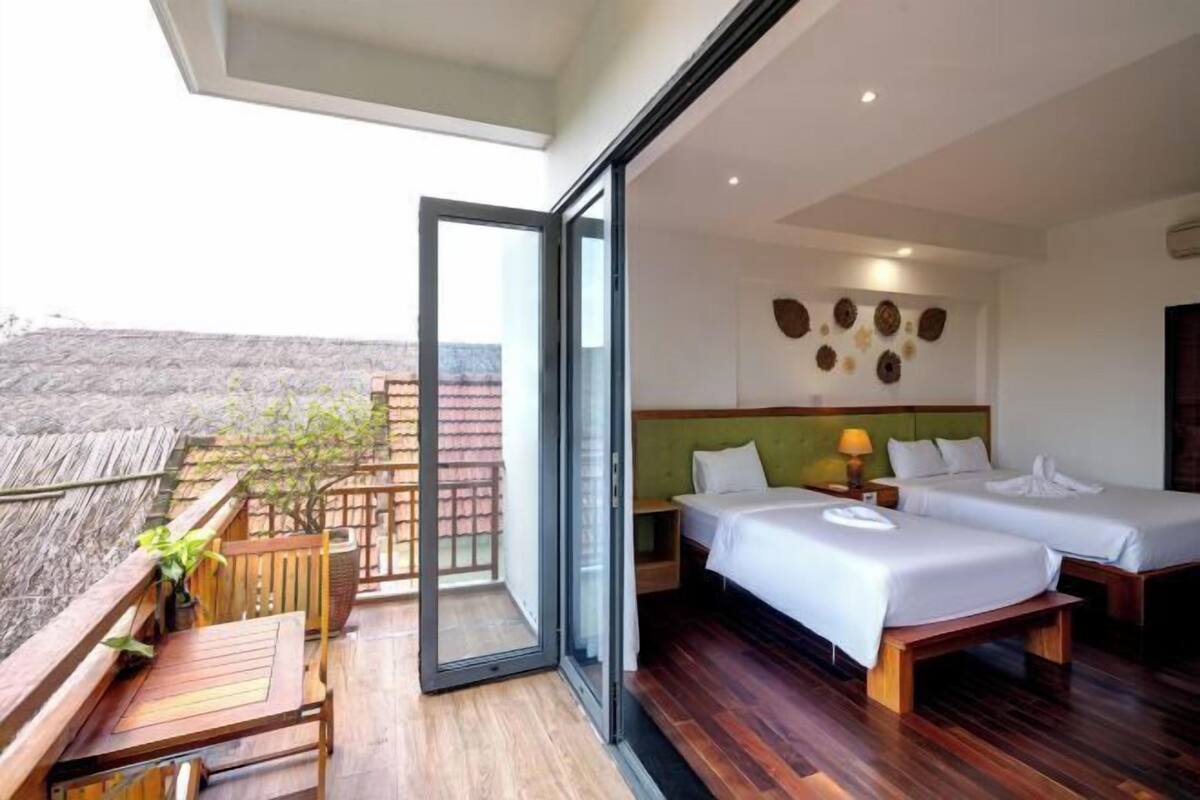 Ein Hotelzimmer mit zwei Betten, einem Balkon und Blick auf die Landschaft.