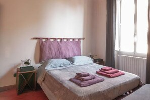 A bed with a headboard, pillows, and folded towels. - Designer Apartments in Florence (Florence)