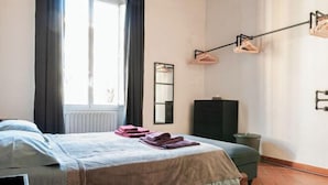 A hotel room with a bed, a dresser, a mirror, and a window with curtains. - Designer Apartments in Florence (Florence)