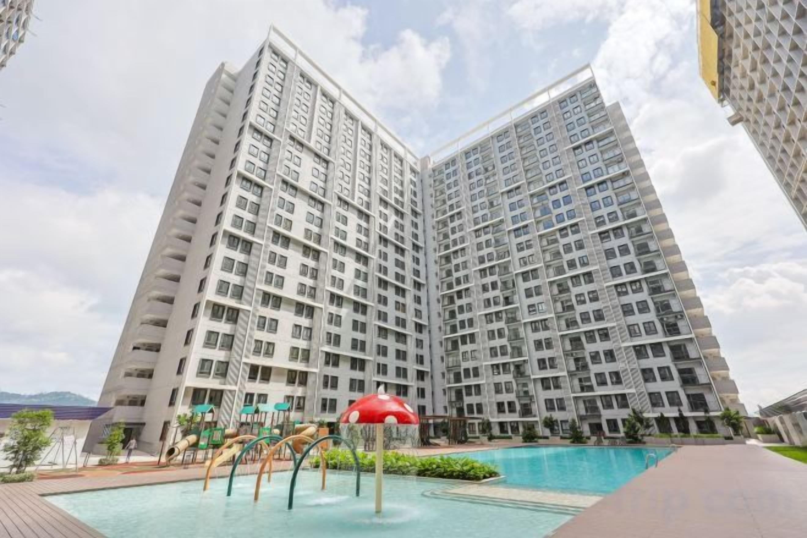 A high-rise residential building with a swimming pool and outdoor play area.