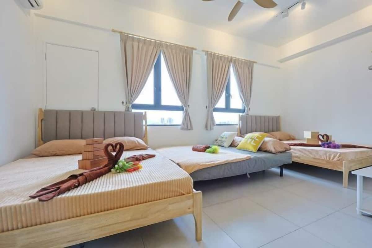 Une chambre d’hôtel avec deux lits, une tête de lit en bois, des rideaux beiges et une porte blanche.