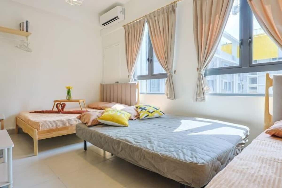 Une chambre avec deux lits, une table de chevet, une chaise et une fenêtre avec des rideaux.