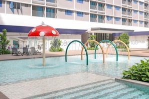 A swimming pool with a mushroom-shaped umbrella, a children's play area, and a building with multiple balconies in the background. - 168 Park Selayang by Fei Hong #Kuala Lumpur #Batu Caves #Kepong #New (Batu Caves)